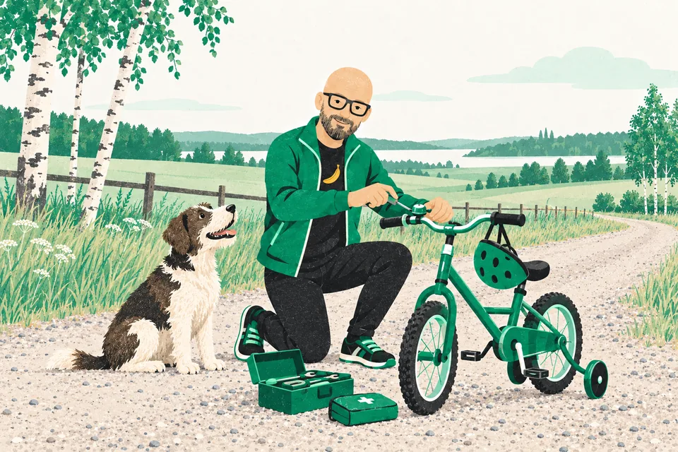 Tecknade Svenne står på ett knä på en grusväg och skruvar fast ringklockan på en liten barncykel med stödhjul och en hjälm på styret, medan en hund sitter bredvid och tittar på.