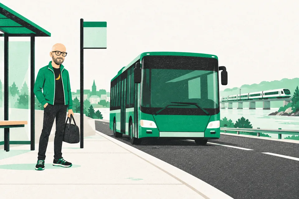 Tecknade Svenne väntar vid en busshållplats medan bussen rullar in och ett tåg syns långt borta.
